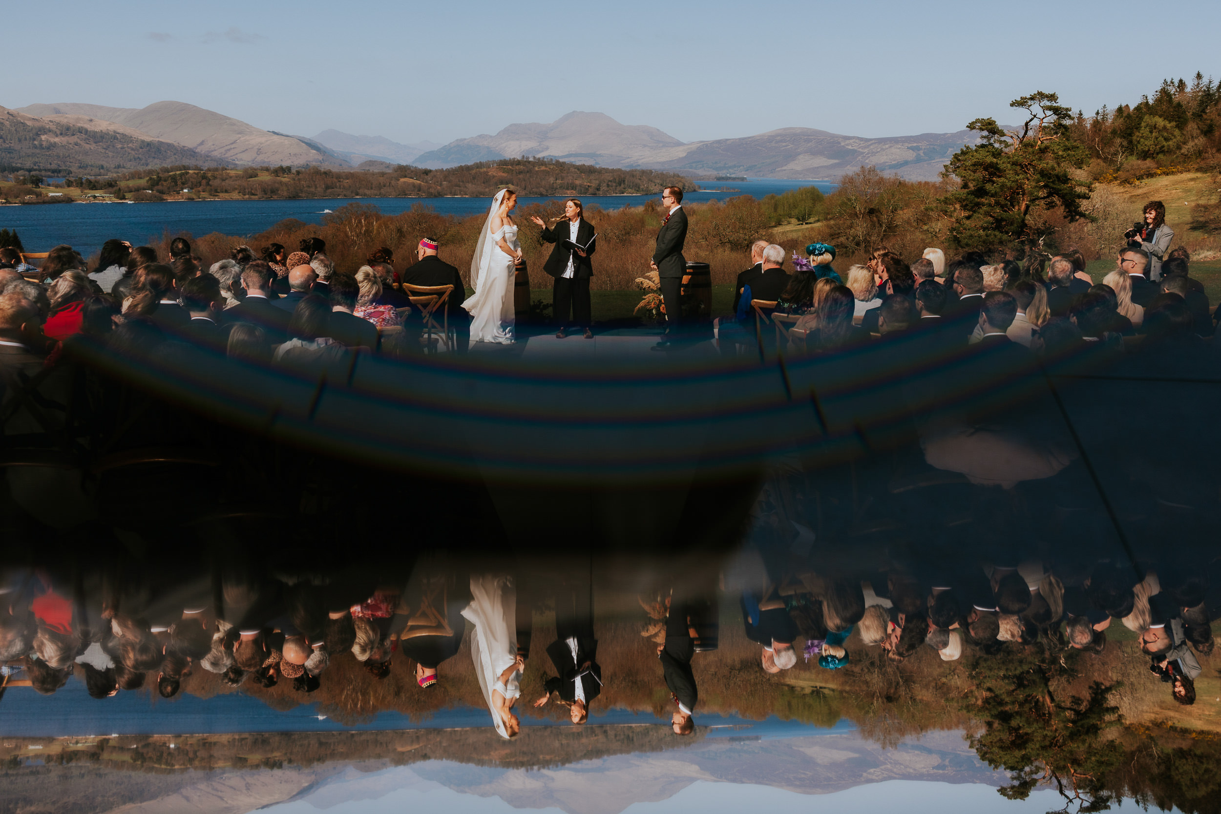 Bride and groom outdoor wedding ceremony at Boturich Castle with Loch Lomond backdrop