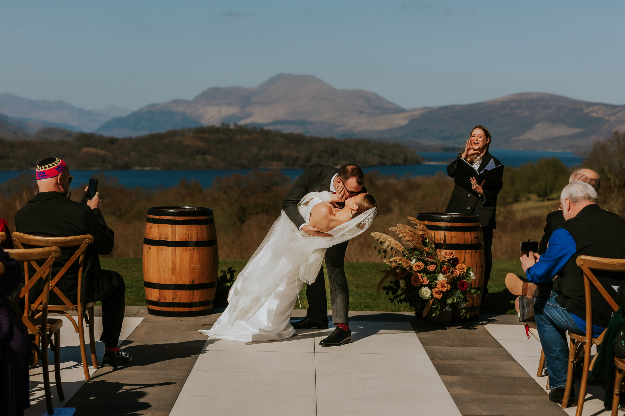 Bride and groom outdoor wedding ceremony at Boturich Castle with Loch Lomond backdrop