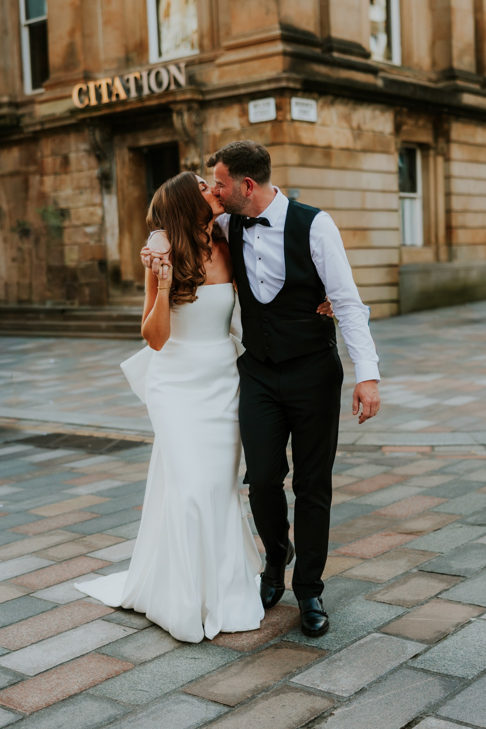 Citation Glasgow wedding photographer 94 Bride and groom kiss while walking hand-in-hand outside the Citation venue in Glasgow.