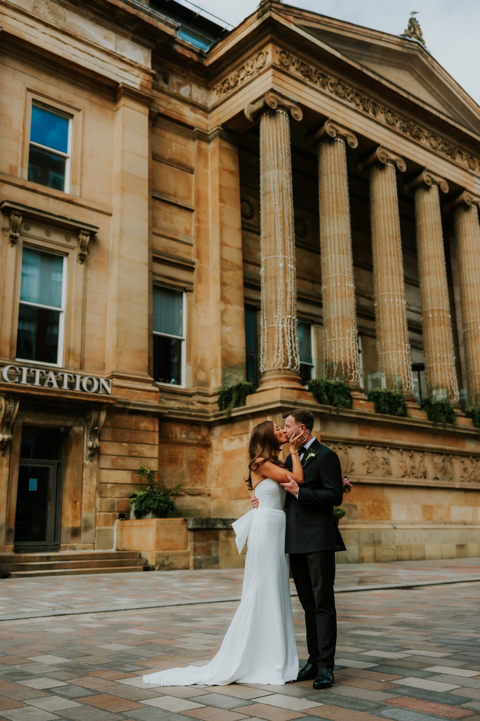 Citation Glasgow wedding photographer 59 Bride and groom kissing outside the grand columned entrance of Citation Glasgow.