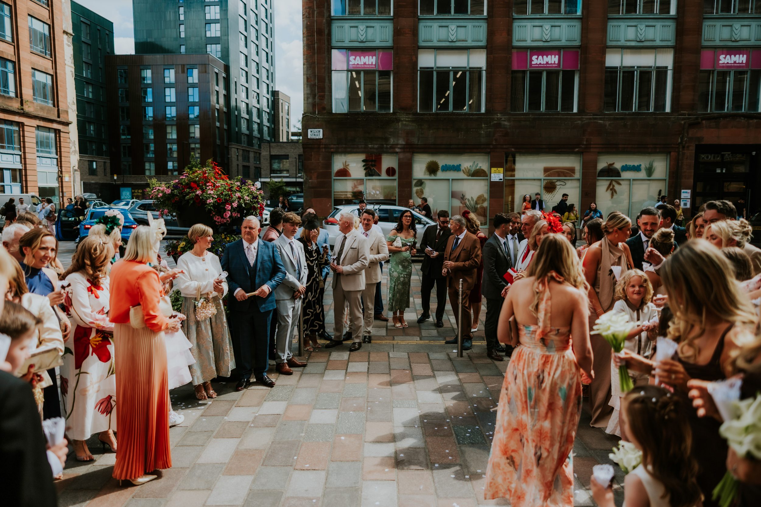 Citation Glasgow wedding photographer 38 Wedding guests gathered outside Citation Glasgow in Glasgow, dressed formally with confetti on the pavement.