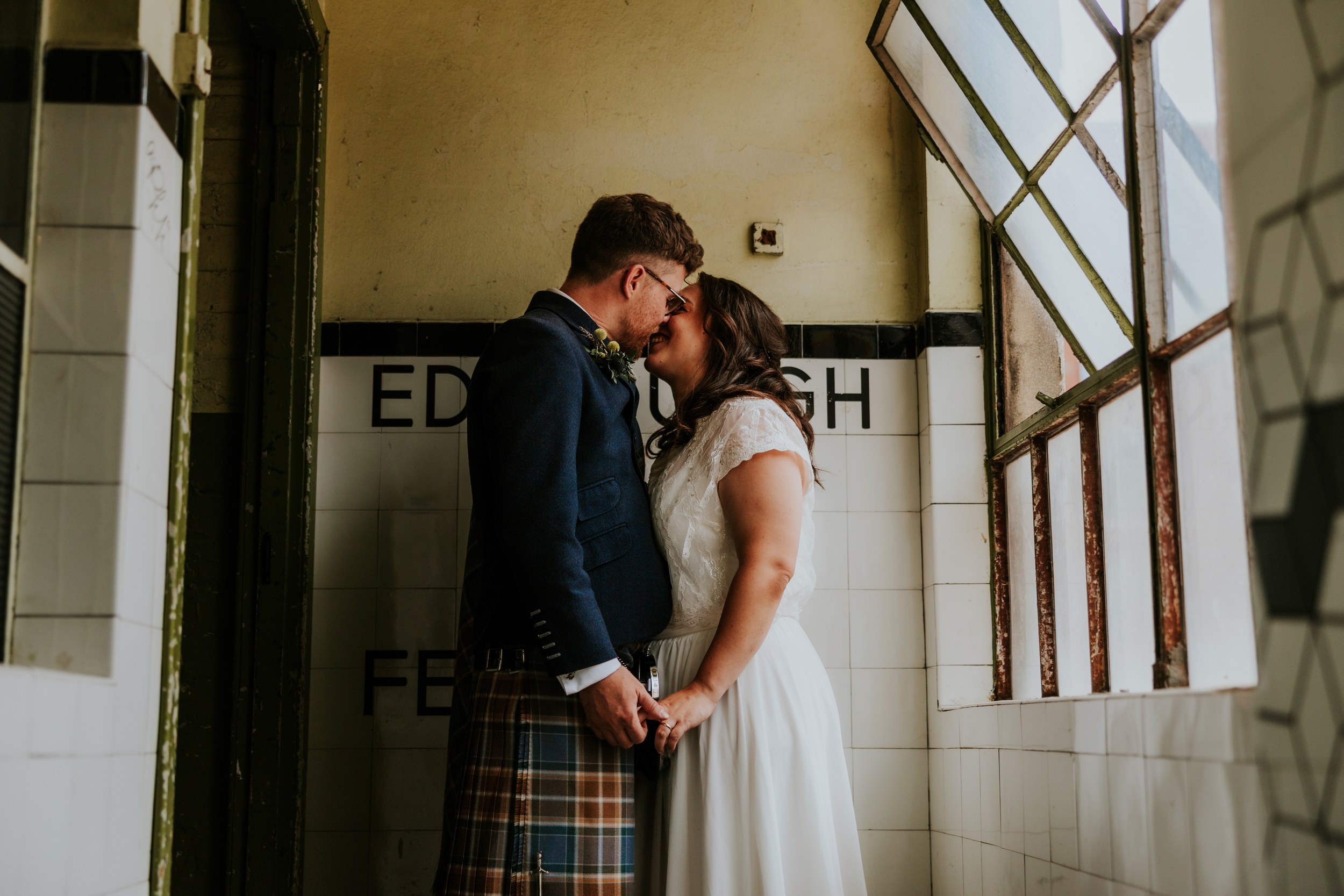 Daniel & Natalie’s Wedding at The Biscuit Factory 47 Daniel and Natalie forehead-to-forehead, holding hands in a tiled corridor by a leaded window at The Biscuit Factory, Edinburgh.