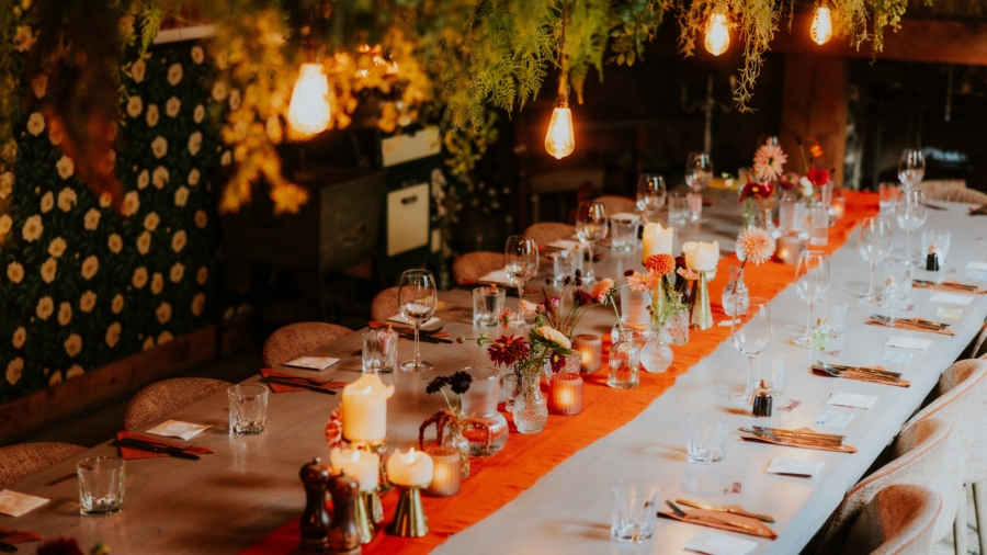 Kelly and Liam’s wedding reception table at The Bothy in Glasgow, set with flowers, candles and glassware.