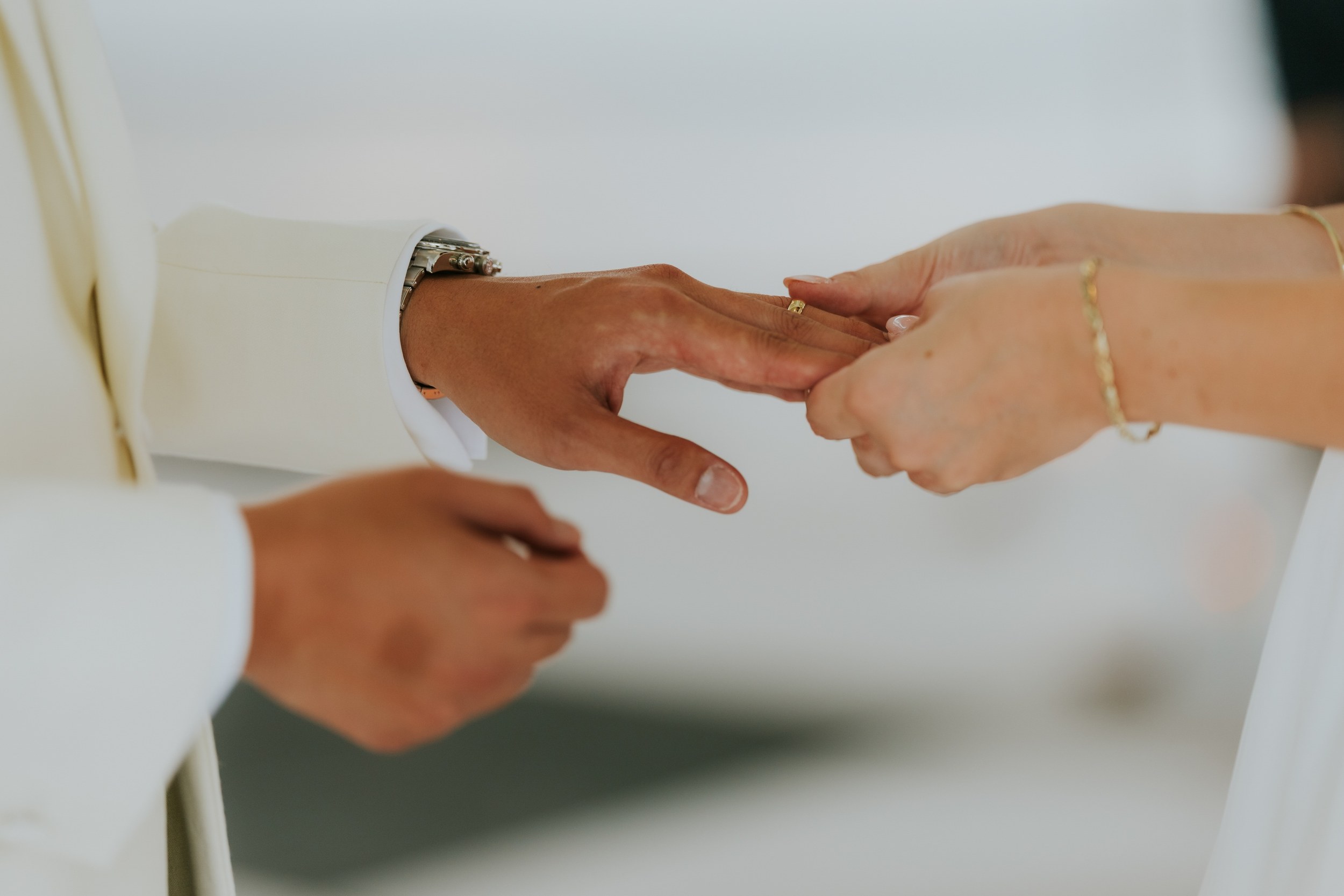 Close-up of Emma placing a wedding ring on Gordon's finger during their ceremony at Lochgreen House Hotel.