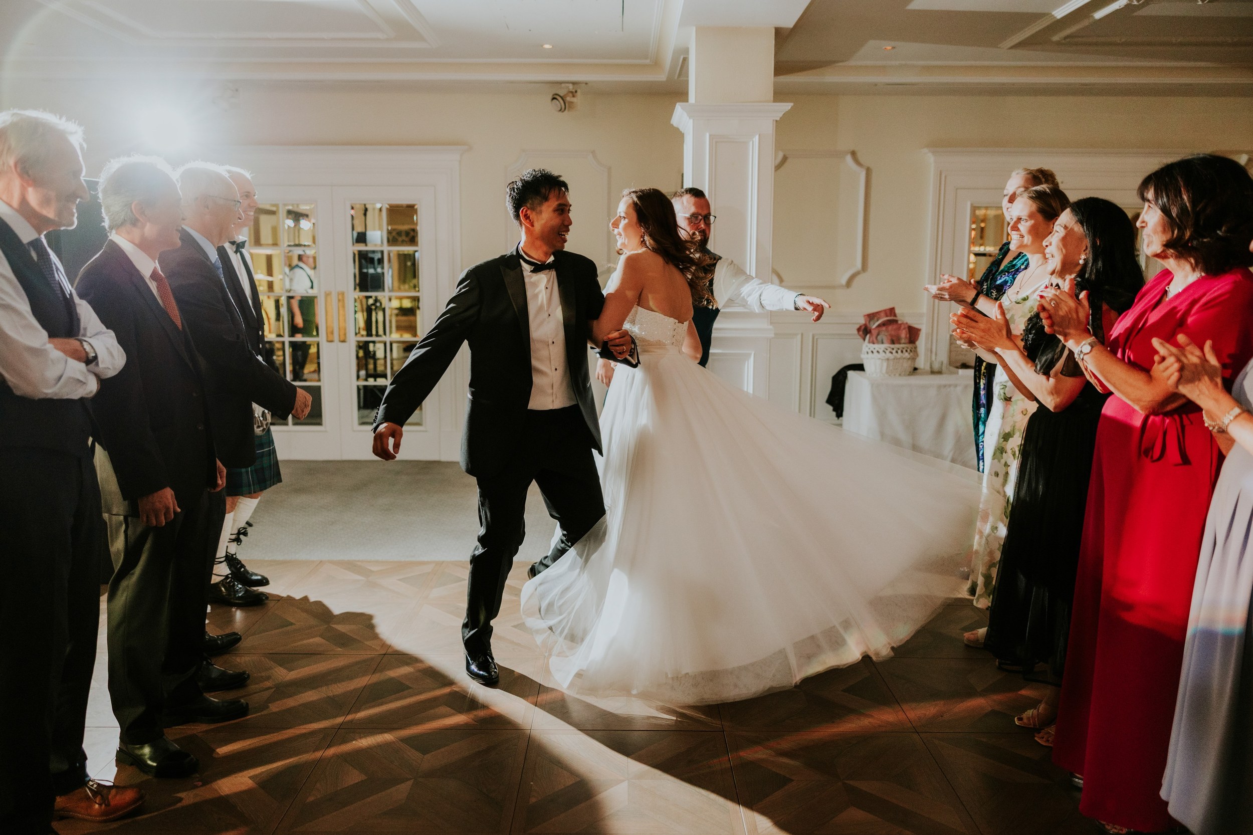 Emma and Gordon dancing between rows of clapping guests at Lochgreen House Hotel.