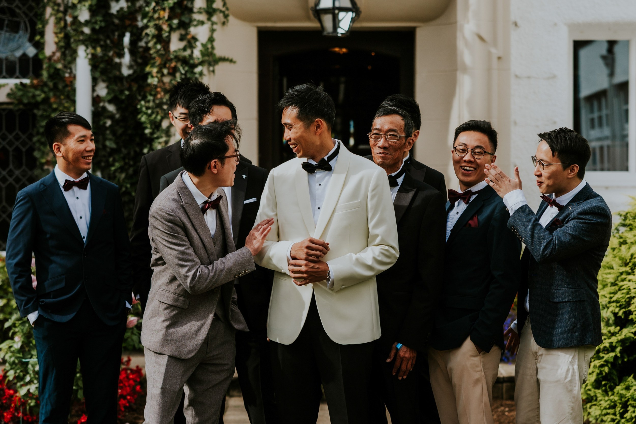 Gordon in a white dinner jacket laughing with a group of men outside Lochgreen House Hotel.