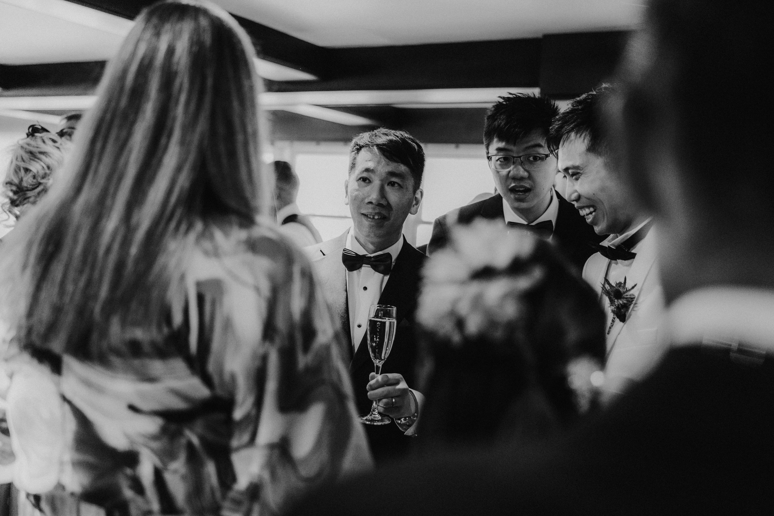 Wedding guests chatting at Lochgreen House Hotel, with a man in a bow tie holding a champagne flute.